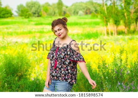 happy girl standing in a green field