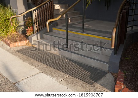 Details of railing and stairs of a modern building. Sidewalk guides for blind. 