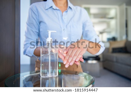 business woman using hand sanitiser in office