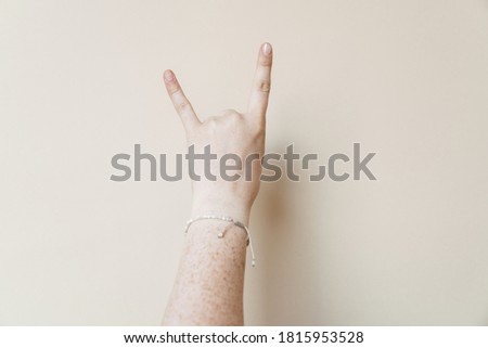 Woman's hand showing horns up gesture isolated
