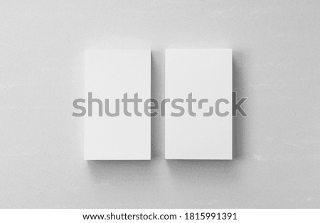 A business card placed on a gray background. Overhead shot.