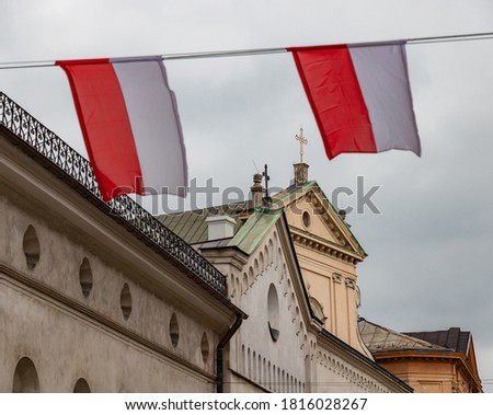 A picture of two Polish flags waving in a street (Krakow).