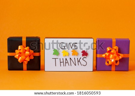 Creative balck and purple present box. Thanksgiving autumn composition on orange background. Lightbox with the phrase Give thanks. Autumn holidays, fall concept.