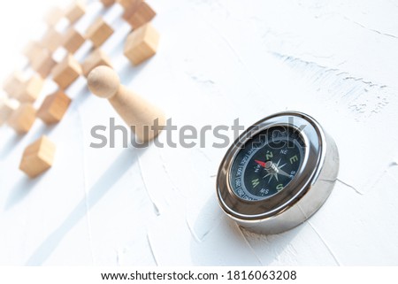 Compass and wooden puppet on a white wooden background, Concept of employee selection