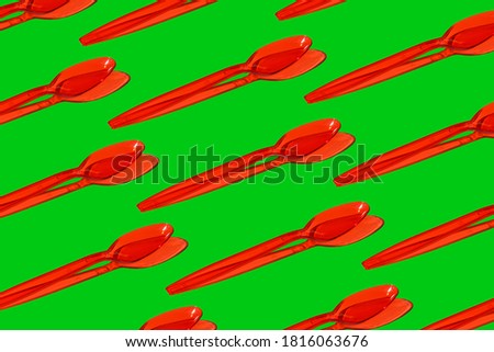 Red plastic spoon on green background