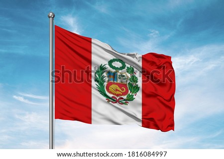Peru national flag cloth fabric waving on beautiful sky.