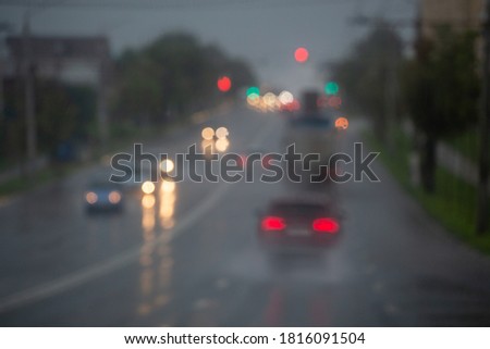 Defocused picture of evening street car traffic after rain - view from road.