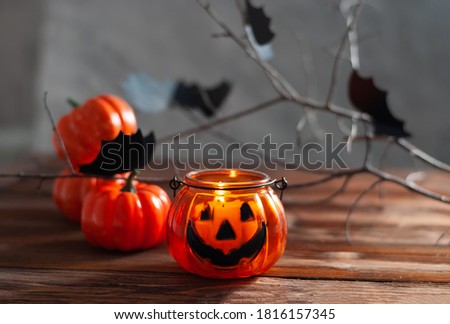 Halloween pumpkins on the wooden table with black wall and garland yellow lights. Happy halloween card beautiful picture