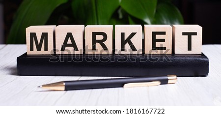 The word MARKET is written on the wooden cubes of the diary near the handle. Marketing concept