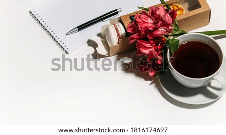 a Cup of coffee, flowers and macaroons on a white background. copy space. flat lay, top view.