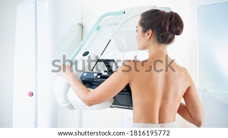 Young woman at breast cancer prevention screening at hospital. Hardware examination of the breast. Healthy young woman doing cancer prophylactic mammography scan. Modern hospital with hi-tech machine Royalty-Free Stock Photo #1816195772