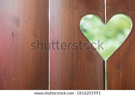 A shape of a heart in a wodden fence. Romantic scene with copy space.