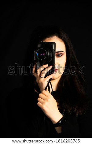 Self portrait of woman taking a photo with vintage camera.