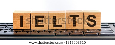 International English language testing system, acronym IELTS - words made of wooden cubes with letters on the keyboard background, education concept
