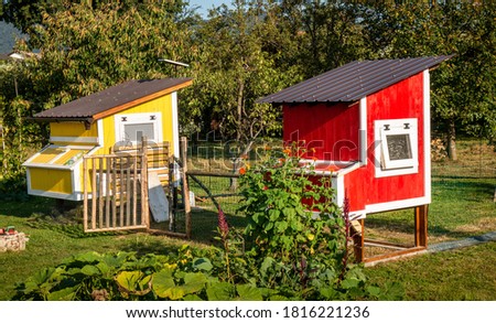 Two beautiful chicken coops near a vegetable garden. Royalty-Free Stock Photo #1816221236