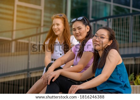 Portrait of the three female students. Asian young woman on front with two blurred women on background. Chinese student.