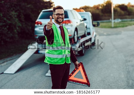 Elegant middle age business man is happy and satisfied with fast towing service for help on the road. He showing thumb up. Roadside assistance concept. Royalty-Free Stock Photo #1816265177
