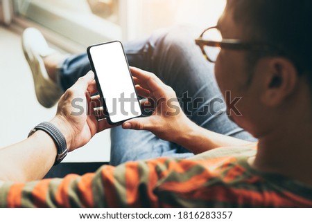 cell phone mockup blank white screen.man hand holding texting using mobile on desk at coffee shop.background empty space for advertise.work people contact marketing business,technology 