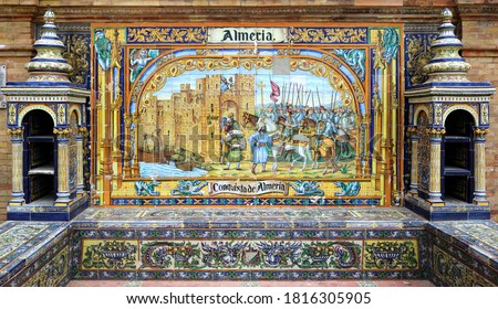 Image with the name of the spanish city of Almeria and a historical scene painted on ceramic tiles - seating benches in Spain Square in Seville
