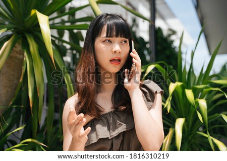 Young asian woman talking on smartphone having problem with boyfriend.