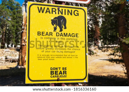 Warning bear damage sign informs tourists about possible car damage on parking lot while leaving food inside the vehicle.