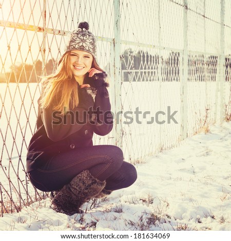 Happy beautiful young Caucasian teenage girl with hat posing outdoors in winter.