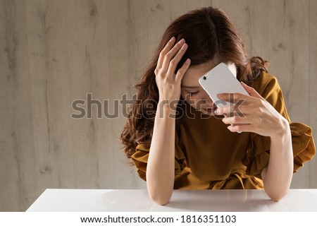 A woman with a smartphone is sad. Royalty-Free Stock Photo #1816351103