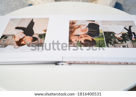 wedding photo book. flipping through a wedding photobook with thick pages on a white table. convenient, beautiful and long-lasting storage of photos from photo sessions.