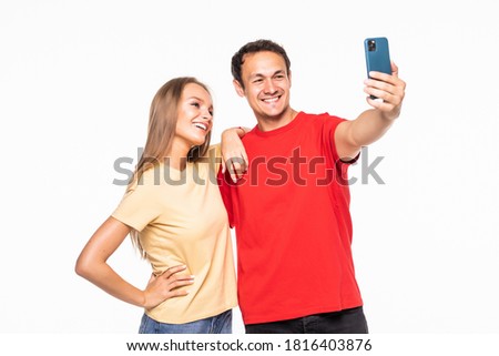 Happy young couple taking a selfie isolated on white background