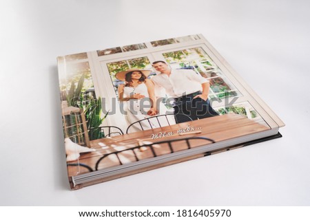 photobook. photo book with thick pages on white table. convenient, beautiful and long-lasting storage of photos from family pregnancy photo sessions. inscription in Russian-waiting for you