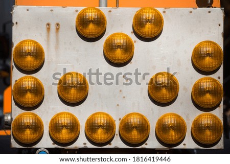 Close up shot of a roadworks signal panel with many yellow lights.