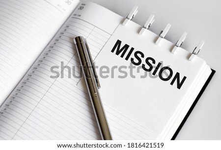 text MISSION on short note texture background with pen