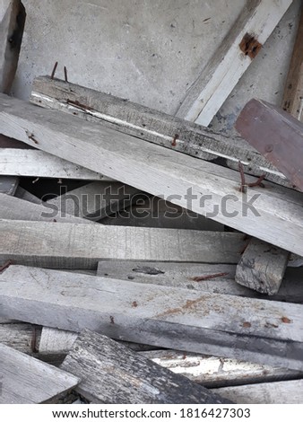 pile of wood blocks with several nails stuck