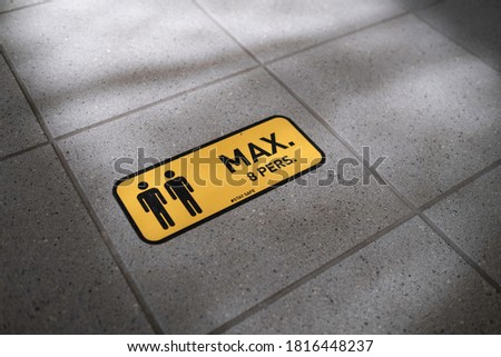 Yellow sticker on the tile floor of a building to indicate that a maximum of 8 people can enter because of corona during covid-19 lockdown. Stay safe
