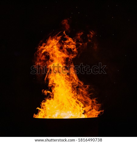 Bright red flame of fire on the background of the black starry sky
