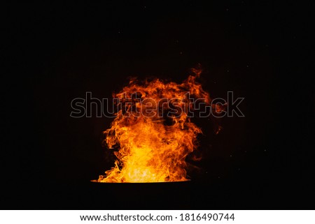 Bright red flame of fire on the background of the black starry sky