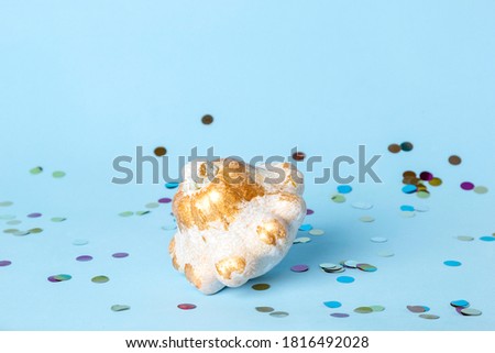Halloween decoration with white pumpkin and colorful confetti on blue background. Thanksgiving composition on modern autumn styled. Trendy holiday concept.