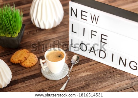 light box message with the text "New life loading" on a wooden table