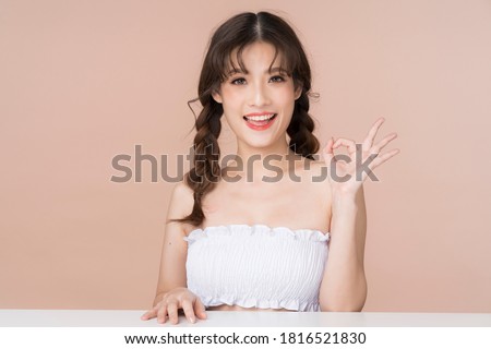 Young asian woman with clean and fresh skin look for cosmetic and spa or healthcare concept advertising acting ok sign hand