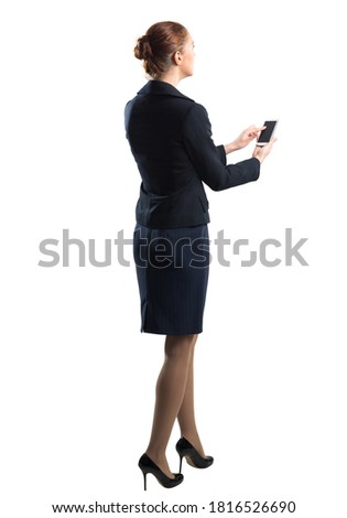 Full body portrait of young woman with smartphone. Side view of confident businesswoman in dark blue suit. Corporate businessperson isolated on white background. Mobile communication layout.
