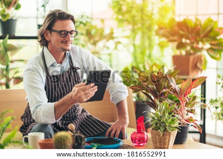 Man in casual outfit doing a hobby with happy and relax enjoy drinking coffee and using tablet for online social in greenhouse garden farm