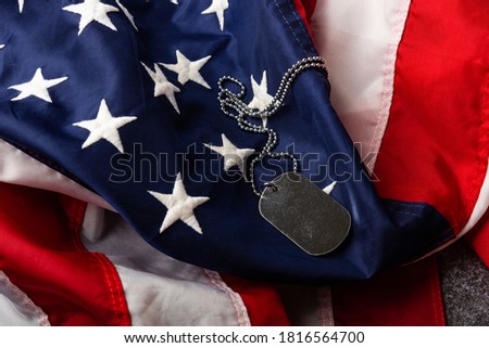 America United States flag and chain dog tags, military symbolizing, studio shot on concrete board background, US Veterans or Independence day concept