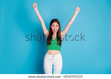 Photo of attractive pretty crazy lady yelling loud raise fists hands up support favorite sports team players competitive wear green dotted crop top white pants isolated blue color background
