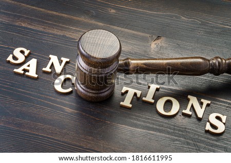Gavel and word sanctions spelled in letters on table Royalty-Free Stock Photo #1816611995