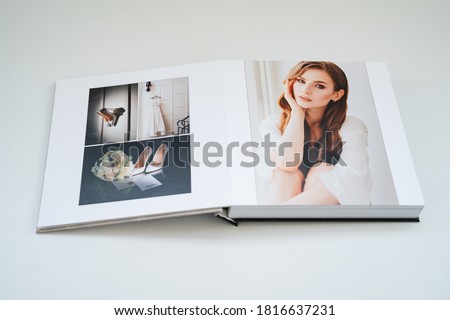 open wedding photo book. flipping through a photobook with thick pages on a white table. convenient, beautiful and long-lasting storage of photos from photo sessions.