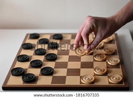 Moving the piece on the draughts board - image Royalty-Free Stock Photo #1816707335