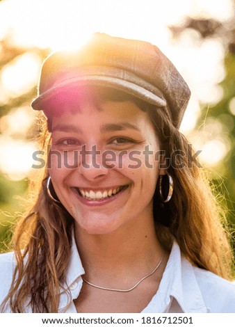 A vertical picture of a brunette female in a white shirt with an amazing smile