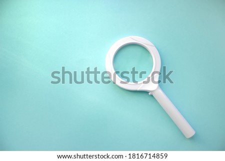 High Angle View Of Magnifying Glass Over Blue Background. Search. Magnifying Glass - Search Engine Optimization
