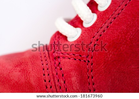Red leather shoe with white lace and stitches for children