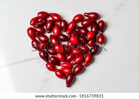 Heart shaped dogwood berries lie on a white background